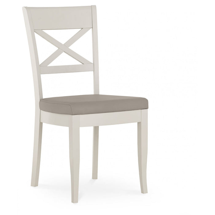 The Montreux Wooden Dining Chair features a white frame, X-shaped backrest, and a light gray cushioned seat, making it perfect for contemporary dining spaces. Shown against a plain white background.