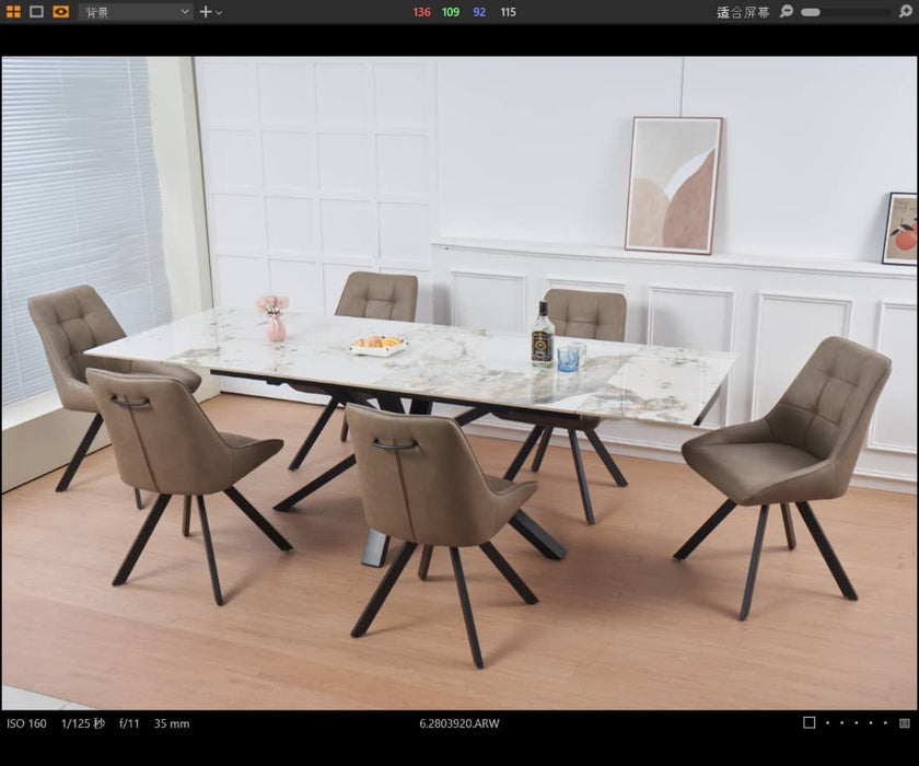 A modern dining room featuring the Sorrento Dining Table and 6 Pedro Chairs, set on light wooden flooring. Minimalist wall art and a flower vase enhance the white-paneled background.