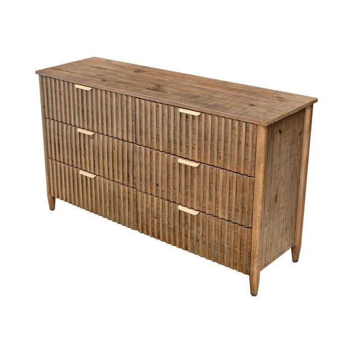 Rustic wooden three-drawer dresser with a vertical reeded or fluted texture across the drawer fronts and slim gold metal pulls.