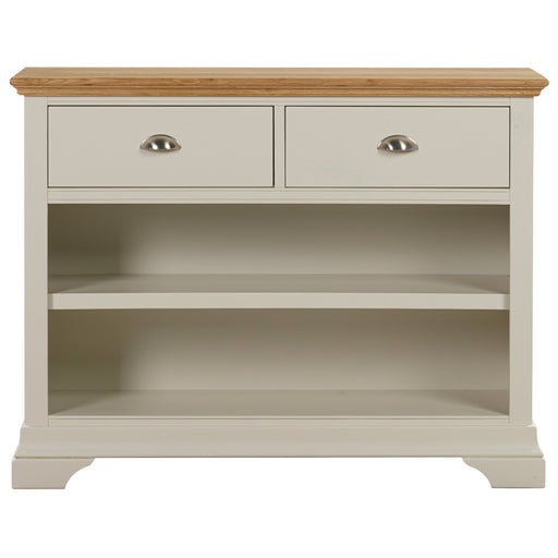 The Anglia Console Table features a cream finish with a wooden top, two metal-handled drawers, two open shelves, and curved feet a stylish contemporary choice for your living room.