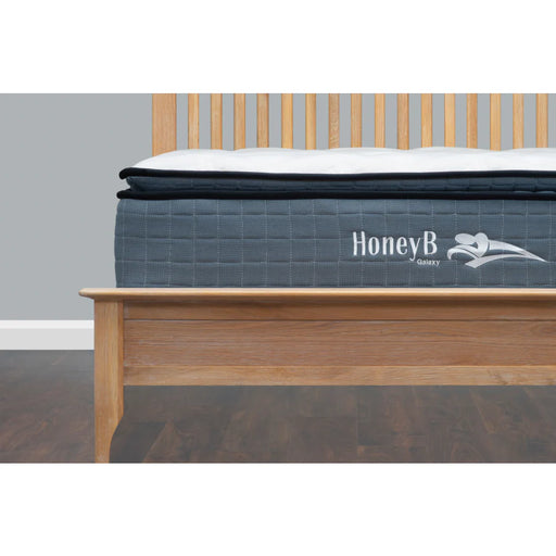 Close-up of a HoneyB Galaxy brand hybrid or pocket sprung mattress with a dark gray quilted side panel and a white pillow top.