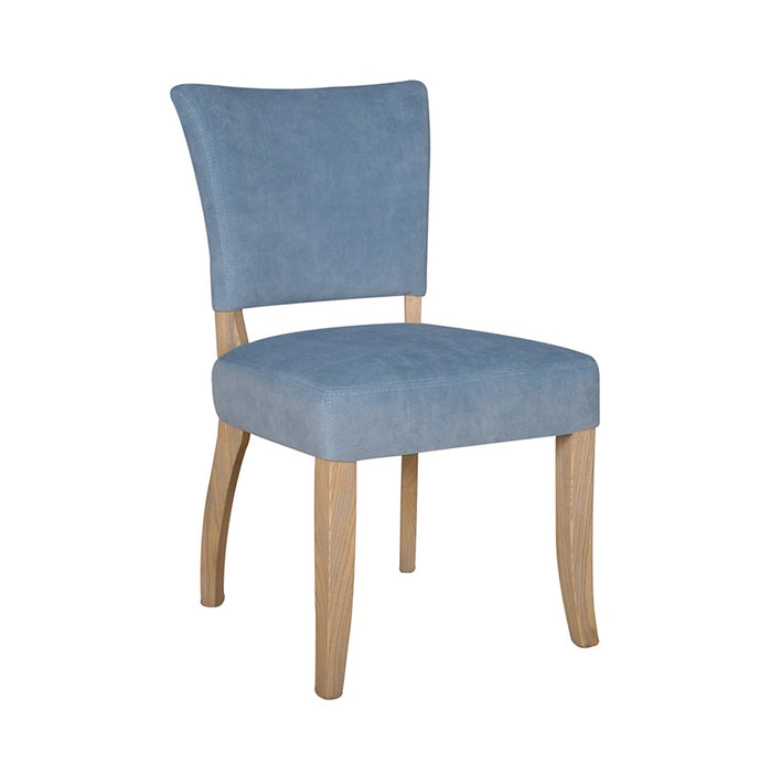 The Duke Dining Chair features a simple, contemporary design with a light blue velvet washable upholstered seat and backrest, set on four natural-finish oak wood legs.