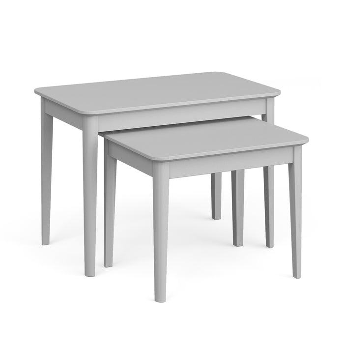 The Stowe Nest Of Tables features two rectangular tables in soft grey with simple, straight legs. The smaller table fits partly under the larger one, highlighting their space-saving design.