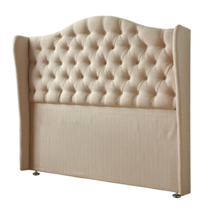 The Respa Miranda headboard features beige upholstery, deep button tufting in a diamond pattern, a curved top edge, winged sides, and stands on small metallic legs against a white background.