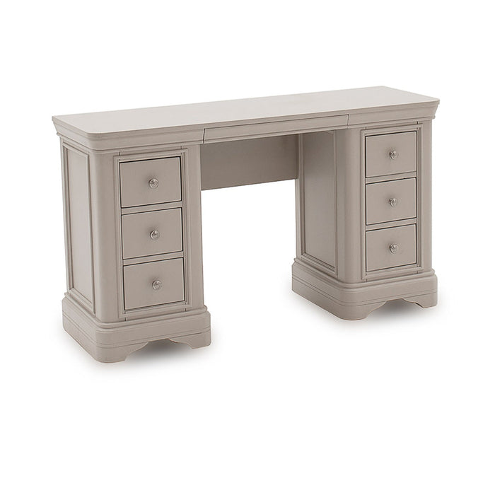 The Mabel Dressing Table by vendor-unknown is a beige wooden desk with six drawers, raised panels, and round metal knobs. Its classic design and flat top make it a stylish addition to contemporary bedrooms.