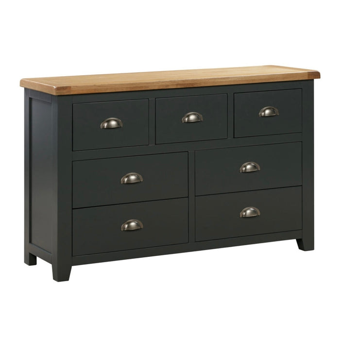 The Capri Dark Wide Chest of Drawers by vendor-unknown features seven drawers, metal handles, a contrasting smokey oak top, sturdy legs, and a high-quality dark gray finish.