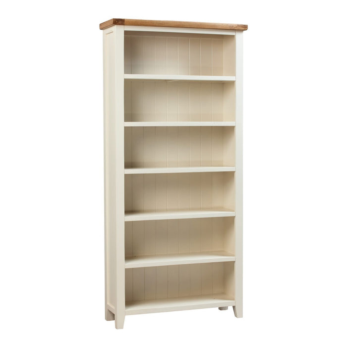 The Skellig Bookcase by vendor-unknown features a tall cream and oak design with a natural wood top, five shelves, panelled back detailing, painted solid hardwood construction, and four small feet. Pictured against a white background.