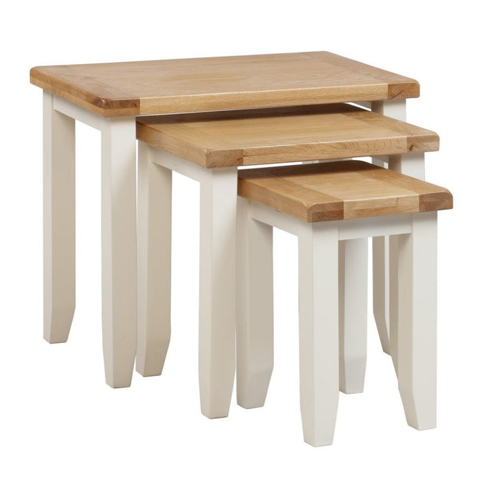 The Skellig Nest of Tables by vendor-unknown features three wooden tables with light brown tops and white solid hardwood legs, designed to nest in size order—a stylish, space-saving addition to any modern furniture collection.