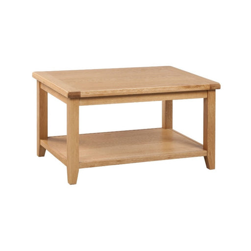 The Saoirse Coffee Table is a rectangular solid oak piece with four legs, a lower storage shelf, a light wood finish, and a simple, sturdy design.