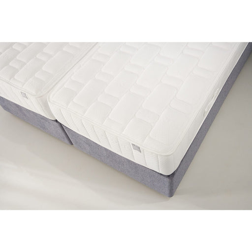 Two King Koil Spinal Guard (ICA) mattresses by vendor-unknown with white quilted covers are placed side by side on gray bases, providing enhanced posture support and forming a spacious sleeping area.