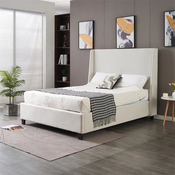 A modern bedroom featuring the Rivera Storage Bedframe in white upholstery, gray and white bedding, a black and white throw, wall art, round rug, potted plant, small side table, and floor-to-ceiling windows with blinds.