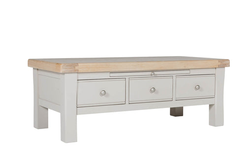 A taupe coffee table with oak veneer top, featuring three small drawers with metal handles.