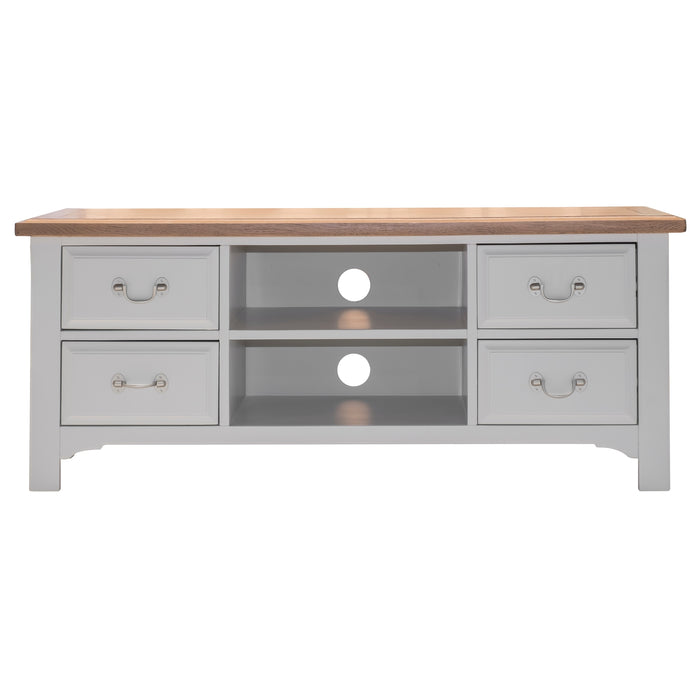 The Eden TV Unit features a solid oak top, soft grey base, four drawers with silver handles, and two central open shelves with circular cable management holes.