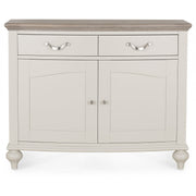 The Montreux Small Sideboard features a light gray finish, wood-finish top, two drawers with silver handles, and two cabinet doors with round knobs on rounded legs—perfect for grey washed oak furniture and modern dining tables.