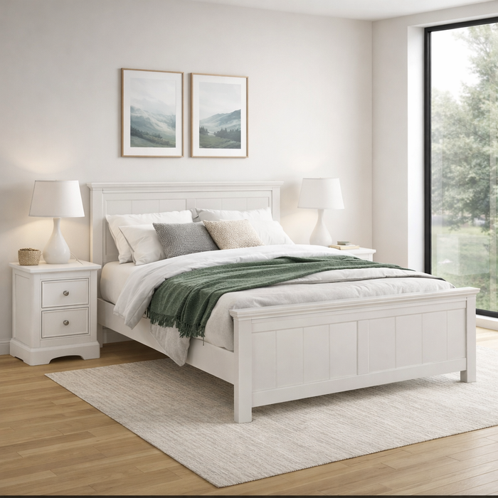 A bright bedroom showcases the Lima Bedframe with a green throw, two nightstands with lamps, framed landscape pictures above the bed, and a large window letting in plenty of natural light.