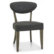 The Ellipse Fumed Oak Upholstered Chair features a quilted back, ideal for complementing industrial-style interiors or a rustic oak dining table.