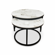 The Kas Nest features two round nesting coffee tables with white marble tops and black metal frames, one smaller table partly tucked under the larger, both displayed on a white background.