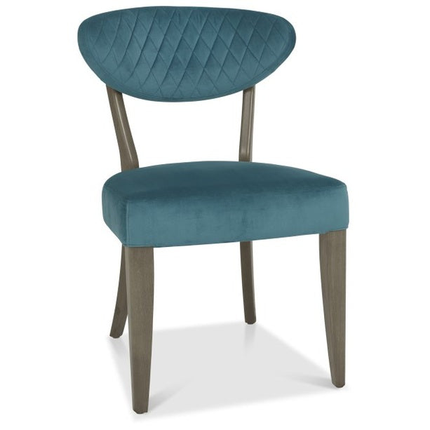 The Ellipse Fumed Oak Upholstered Chair features blue fabric and wooden legs, ideal for pairing with fumed oak furniture or introducing a touch of industrial style to any room.