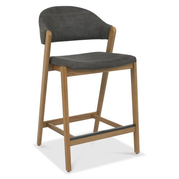 The Camden Counter Stool features a modern retro design with a padded dark gray seat, curved backrest, light wood frame, and metal footrest.