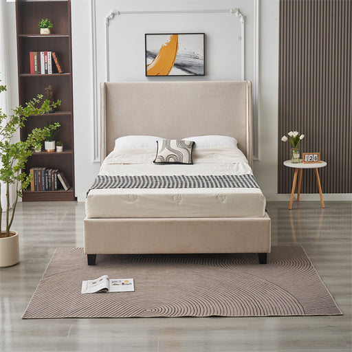 A modern bedroom showcases the Rivera Storage Bedframe in beige linen with patterned pillows, a side table holding flowers and a clock, a decorated bookshelf, potted plant, and an open book on a rug over light gray flooring for stylish storage.