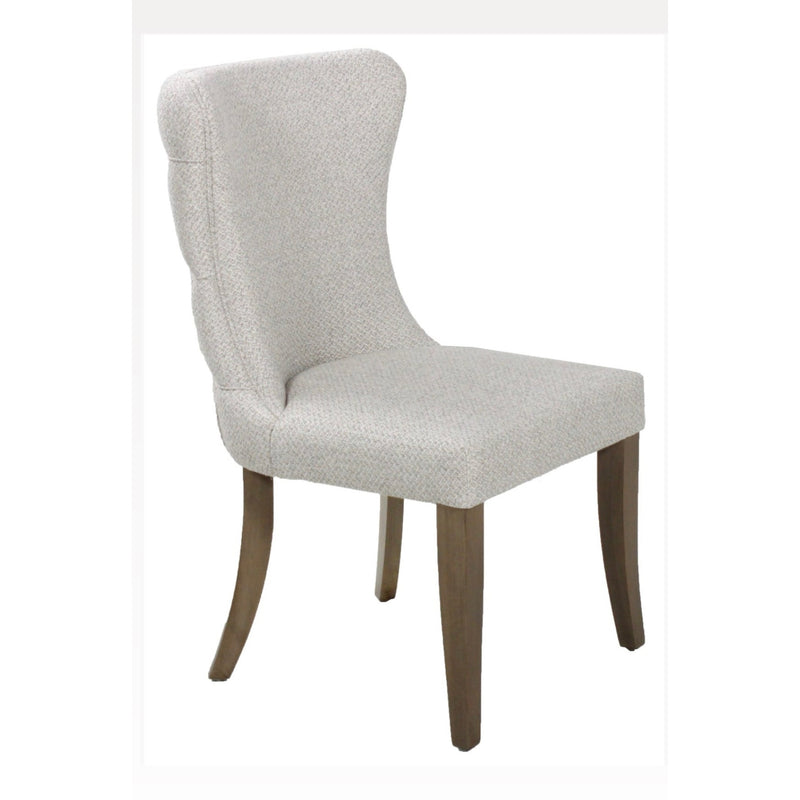The Duke Chair is a modern upholstered dining chair with light beige fabric, a curved backrest, and four oak legs. Its straight front legs and subtly curved back legs add an elegant touch to any dining space.