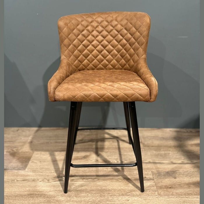 The Diamond Counter Stool features brown PU leather with diamond-patterned quilting, a curved backrest, and black metal legs—ideal as a stylish seating option for your kitchen island.