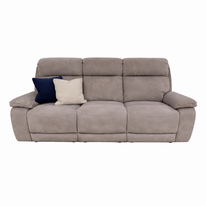 The Newbury Recliner Sofa is a light gray, contemporary piece with plush cushions and seating for three. It features two throw pillows—navy blue and cream—on the left side. Easy-clean fabric makes it ideal for daily use. Shown on a plain white background.
