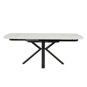 The Positano Swivel Dining Table features a modern rectangular design with X-shaped black metal legs and a sleek ceramic top, shown against a plain white background.