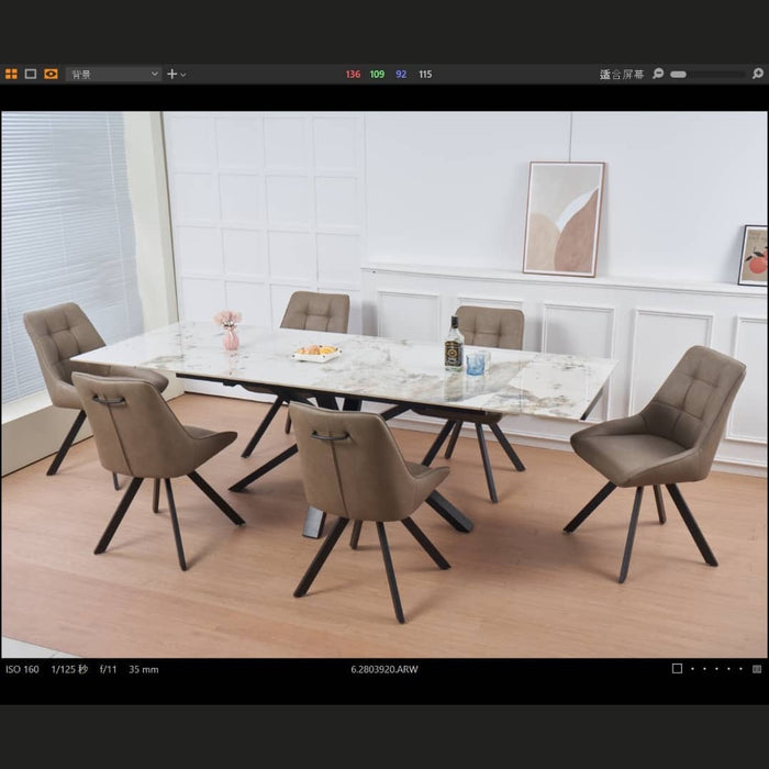 A modern dining room featuring the Sorrento Dining Table and 6 Pedro Chairs, set on light wooden flooring. Minimalist wall art and a flower vase enhance the white-paneled background.