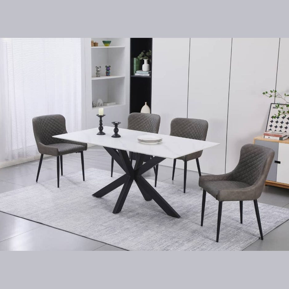 A contemporary dining set featuring a white rectangular table with a black cross-shaped base and six gray upholstered chairs with a diamond pattern and metal legs.