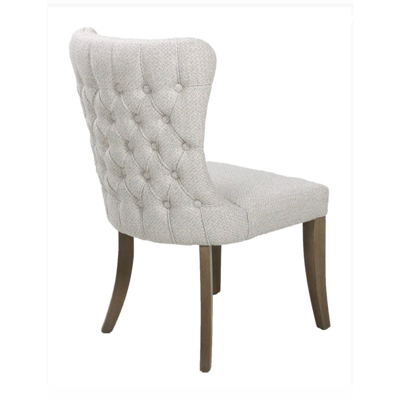 The Duke Chair features light gray upholstery, a button-tufted backrest, and dark oak legs. Shown from an angle, the image highlights the chair’s back and one side.
