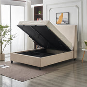 The Rivera Storage Bedframe in beige linen features a lift-up mattress revealing hidden storage, set in a modern bedroom with a plant, rug, bookshelf, and framed artwork on the wall.