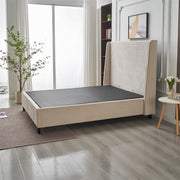 A modern bedroom featuring the Rivera Storage Bedframe in beige linen with a tall headboard (no mattress). Light wood floors, a round rug, potted plants, and sheer-curtained windows complete the stylish storage solution.