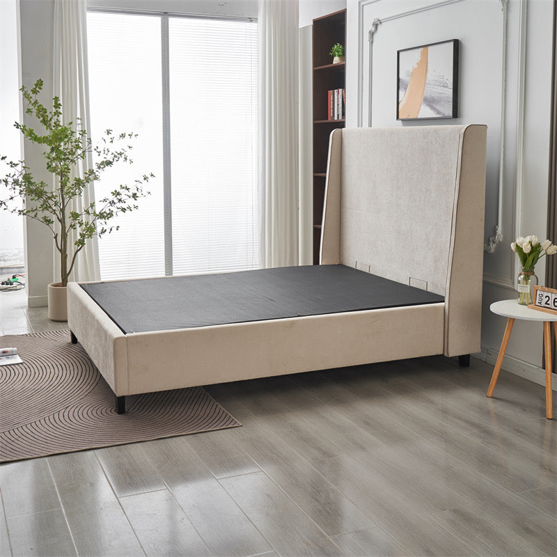 A modern bedroom featuring the Rivera Storage Bedframe in beige linen with a tall headboard (no mattress). Light wood floors, a round rug, potted plants, and sheer-curtained windows complete the stylish storage solution.