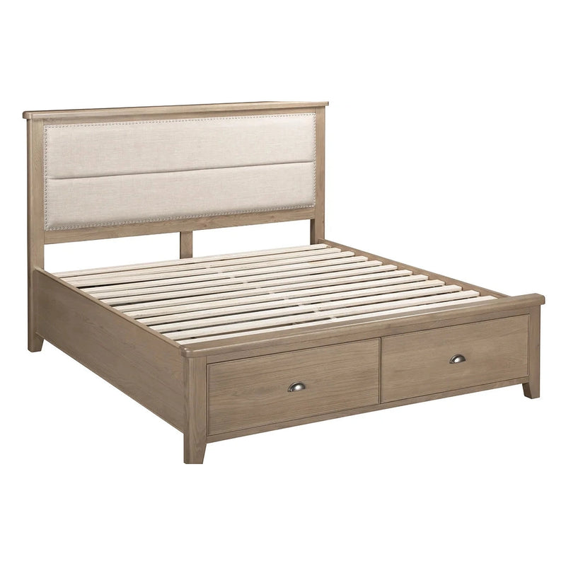 The Aylesbury bedframe boasts a beige padded headboard, two foot-end storage drawers, and sturdy wooden slats in an oak finish—combining stylish design and practical function for any bedroom.