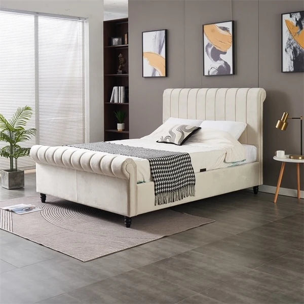 A modern bedroom featuring the Ascot Storage Bedframe in cream velvet, black-and-white blanket, decorative pillows, gray accent wall, abstract art, potted plant, small side table with lamp, and a window with blinds.
