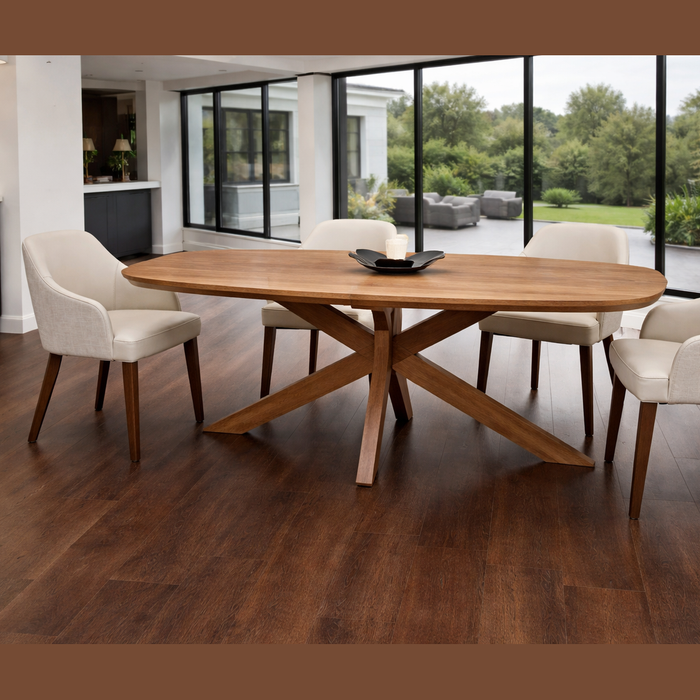 A modern dining room featuring the Ashton Dining Table with an architectural base, four white upholstered chairs, a black centerpiece, all set on dark wood flooring with large windows showcasing a lush green view.