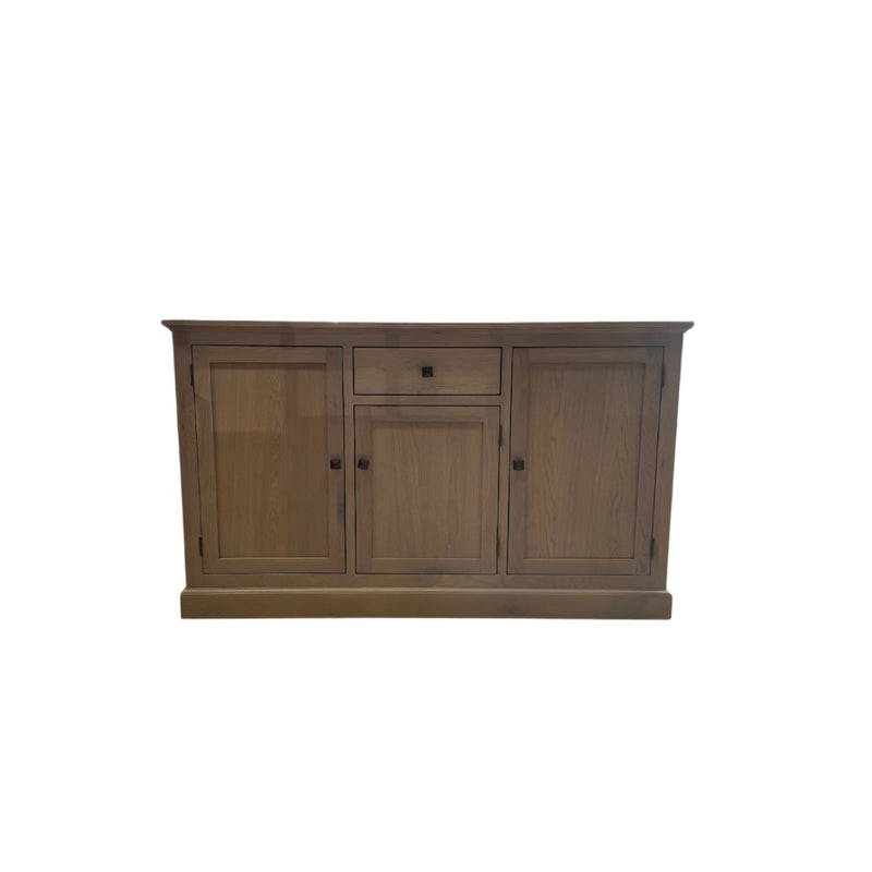 A wooden sideboard with a grey wash finish featuring three cupboards and a drawer.