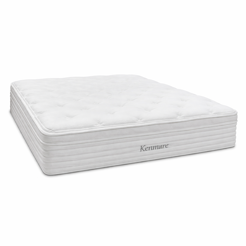 The Kenmare Mattress is a white, rectangular pocket spring mattress with a quilted, tufted surface and "Kenmare" embroidered on the side. Its thick profile features horizontal stitching and provides edge-to-edge support for comfort.