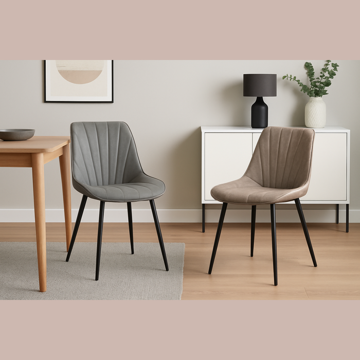 Two Lilly Dining Chairs with black legs are placed in a minimal dining room featuring light wood floors, a wooden table, a white sideboard, a black lamp, a bowl, and an abstract print on the wall.