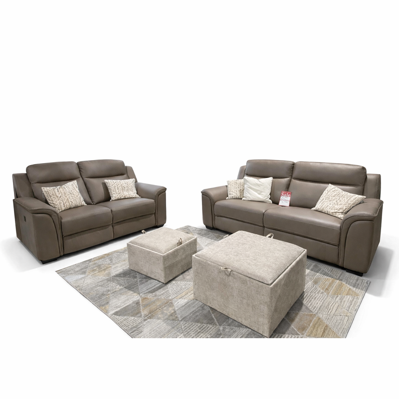 The Samantha 3+2 set includes two brown genuine leather sofas with patterned and plain cushions, arranged on a gray geometric rug with two beige ottomans. A sale tag appears on one sofa. Modern living room look, shown on a plain white background.