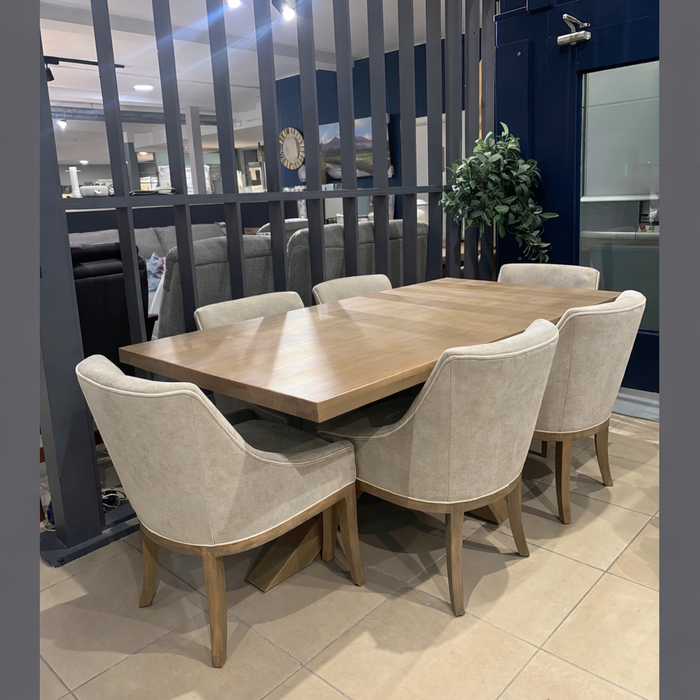 A modern dining area showcases a rectangular wooden table surrounded by six Louis Dining Chairs with contrast piping, set on a tiled floor by a vertical slat partition and accented with a nearby potted plant.