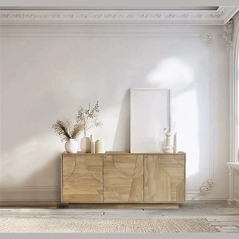 A bright room with ornate white walls, a large arched window, and the Dakota 3 Door Sideboard – Oak topped with neutral vases, dried grasses, and a blank frame.