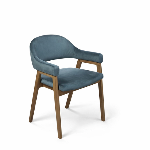The Camden Armchair features a curved, upholstered blue velvet seat and backrest, angled wooden legs, and open sides, all set against a plain white background.