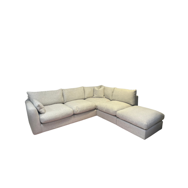 The Casablanca Corner Sofa is a light gray L-shaped piece with plush cushions and deep seats, featuring a right-side chaise lounge and easy-care aqua clean upholstery, shown isolated on a white background.