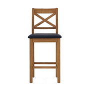 The Salisbury Barstool features a cross-back wooden design, rustic knotty White oak construction, and a black cushioned seat, shown here against a white background.