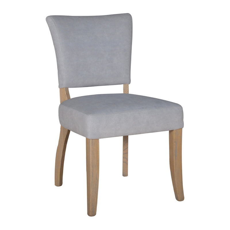 The Duke Dining Chair features a modern, minimalist design with slightly curved oak legs and an upholstered light gray washable velvet seat and backrest.