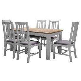 The Eden dining table, featuring a small extendable washed natural oak top, comes with six matching gray chairs, offering a stylish and cozy dining setup.