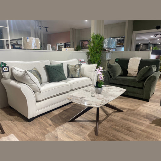 The modern living room set features the Savoy sofa by vendor-unknown in white aquaclean fabric with assorted pillows, a green armchair, marble-patterned coffee table, and potted orchid on wood flooring, accented by plants and decor.