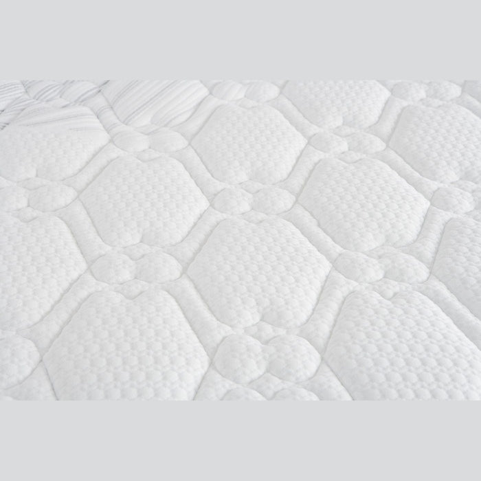 Close-up of the King Koil Paradise Mattress surface, featuring a soft, padded white fabric with a quilted hexagon and circle pattern. Flex-edge border supports and detailed stitching enhance comfort, support, and varied texture.